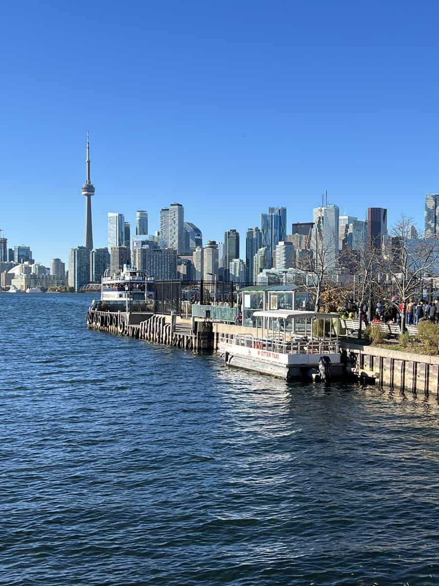 Ward's Island ferry dock with city ferry and water taxi with the Toronto skyline in the background.